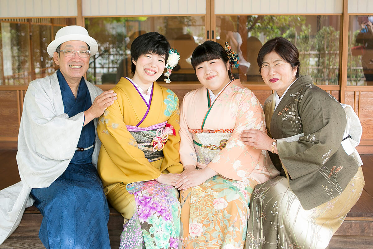 父は青の着物、母は緑の着物、長女はピンク色の着物、次女は黄色い振袖