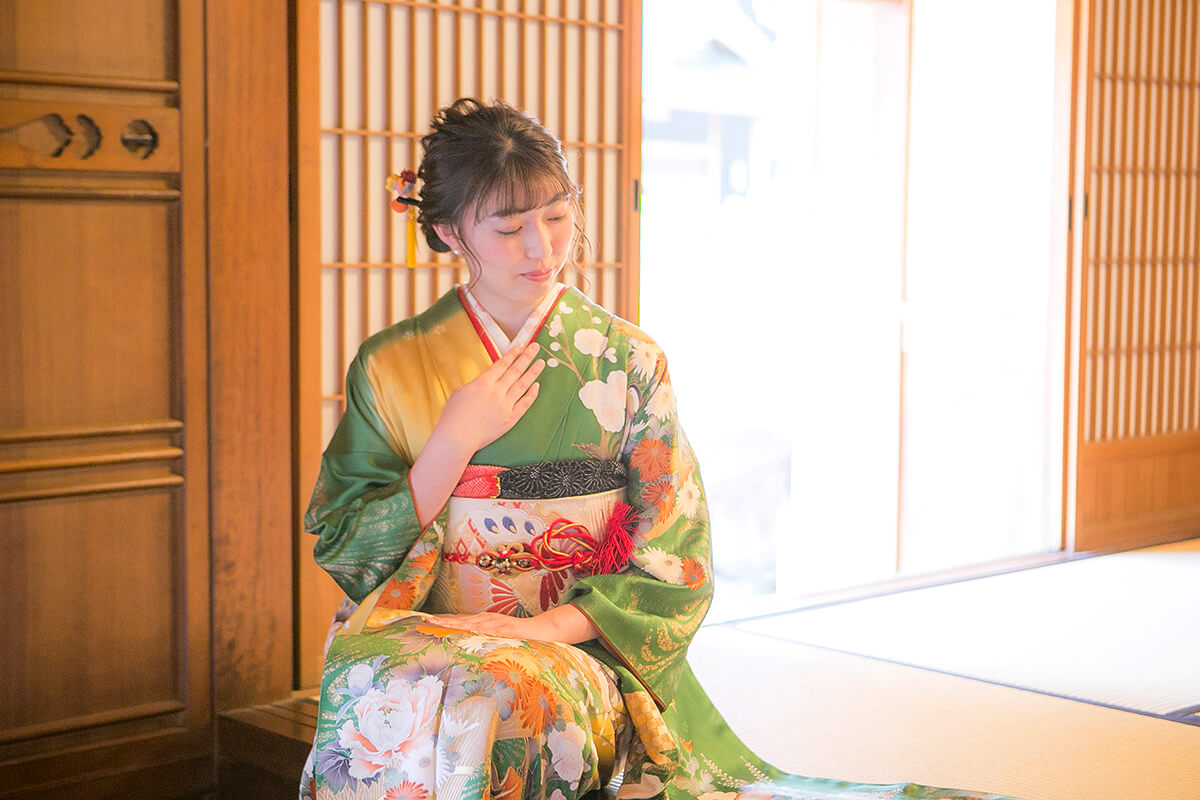 緑色の振袖を着た二十歳の女性
