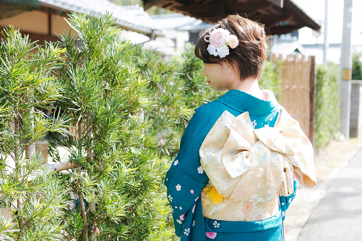 青色の振袖を着た二十歳の女性